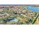 Expansive aerial view showcasing the community, a tranquil lake, and a well-maintained tennis court at 4232 Prima Lago Dr, Lakeland, FL 33810