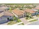 Aerial of home with manicured landscaping, paver driveway and walkways with beautiful trees in the background at 4232 Prima Lago Dr, Lakeland, FL 33810