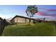 Spacious backyard with green grass, complemented by a screen enclosed patio and secure black metal fencing at 4232 Prima Lago Dr, Lakeland, FL 33810