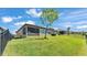 Spacious backyard with green grass, complemented by a screen enclosed patio and secure black metal fencing at 4232 Prima Lago Dr, Lakeland, FL 33810