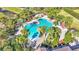 Resort-style community pool featuring a unique guitar shape, surrounded by lush landscaping and comfortable lounge areas at 4232 Prima Lago Dr, Lakeland, FL 33810