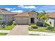 Inviting home exterior with a well-maintained lawn, tile roof, brick driveway, and lush landscaping at 4232 Prima Lago Dr, Lakeland, FL 33810