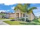 Front exterior view showcases a charming home with a tropical palm and manicured landscaping at 4232 Prima Lago Dr, Lakeland, FL 33810