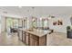 Kitchen island with sink and granite counters connects to dining and living space at 4232 Prima Lago Dr, Lakeland, FL 33810