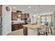 Modern kitchen boasts granite countertops, stainless steel appliances, island seating, and warm wood cabinets at 4232 Prima Lago Dr, Lakeland, FL 33810