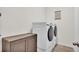 Functional laundry room with front-load washer and dryer, plus convenient cabinet storage at 4232 Prima Lago Dr, Lakeland, FL 33810