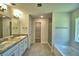 Bathroom featuring dual sinks, a soaking tub, glass-enclosed shower, and walk-in closet at 4322 Juliana Lake Dr, Auburndale, FL 33823