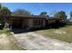 Single story brick home with a covered carport and a well-manicured lawn at 460 W Pierce St, Lake Alfred, FL 33850