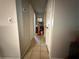 Neutral hallway featuring tile floors with a view of a round mirror and shelves at 460 W Pierce St, Lake Alfred, FL 33850