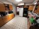 Kitchen with tiled floor, wooden cabinets, and appliances including an oven, refrigerator, and microwave at 460 W Pierce St, Lake Alfred, FL 33850