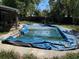 Outdoor pool area features a blue pool cover at 460 W Pierce St, Lake Alfred, FL 33850
