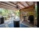 Covered patio featuring a corrugated roof, outdoor grill, and a charming outdoor swing for relaxation at 530 Heather Ct, Bartow, FL 33830