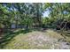 A spacious backyard with mature trees and a small outbuilding visible in the distance at 530 Heather Ct, Bartow, FL 33830