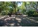 Lush, green backyard featuring mature trees and garden area provides a serene retreat at 530 Heather Ct, Bartow, FL 33830