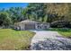 Single-story home featuring a driveway and a well-manicured front yard with mature trees at 530 Heather Ct, Bartow, FL 33830
