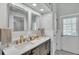 Bathroom with dual sinks, marble countertops, gold fixtures, white subway tile, and a door to the outside at 5638 Bloomfield Blvd, Lakeland, FL 33810
