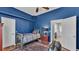 A dark blue bedroom has doors leading to other rooms and a bed with a plaid blanket and pillows at 5638 Bloomfield Blvd, Lakeland, FL 33810