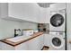 Bright laundry room boasts stacked washer and dryer, light green walls, and butcher block countertops at 5638 Bloomfield Blvd, Lakeland, FL 33810