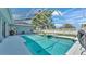 Screened-in pool with inset spa, white concrete surround, blue exterior, and outdoor grill area at 5638 Bloomfield Blvd, Lakeland, FL 33810