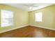 An empty bedroom with two large windows, wood floors and bright yellow walls at 5789 Lake Victoria Dr, Lakeland, FL 33813