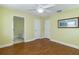 Bedroom with hardwood floors, ceiling fan, and ensuite bath and closet doors at 5789 Lake Victoria Dr, Lakeland, FL 33813