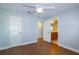 A bright bedroom with wood floors, a ceiling fan, and access to a bathroom at 5789 Lake Victoria Dr, Lakeland, FL 33813