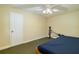 Bedroom with a blue bedspread, ceiling fan and an exercise machine at 5789 Lake Victoria Dr, Lakeland, FL 33813