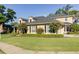 Beautiful two-story home with manicured landscaping, colorful flowering trees, and a lush green lawn under a clear sky at 5789 Lake Victoria Dr, Lakeland, FL 33813
