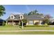 Charming two-story home featuring dormer windows, manicured lawn, and lush landscaping at 5789 Lake Victoria Dr, Lakeland, FL 33813