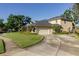 Beautiful two-story home with well-manicured lawn, mature trees, and paved driveway at 5789 Lake Victoria Dr, Lakeland, FL 33813