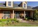 Inviting brick front porch with elegant columns, seating, and lush landscaping at 5789 Lake Victoria Dr, Lakeland, FL 33813