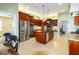 View of kitchen with stainless steel appliances and wood cabinets, and a view to the dining room at 5789 Lake Victoria Dr, Lakeland, FL 33813