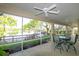Screened patio with ceiling fans, outdoor furniture, and a lovely view of the backyard and lake at 5789 Lake Victoria Dr, Lakeland, FL 33813