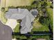 Aerial view of a home with meticulous landscaping, large driveway, and screened pool at 6470 Ashley Dr, Lakeland, FL 33813