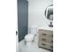 This bathroom offers a modern vanity with a round mirror and stylish shiplap accent wall at 6470 Ashley Dr, Lakeland, FL 33813