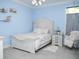 Cozy bedroom with light blue walls, a white bed, and a hanging chair at 6470 Ashley Dr, Lakeland, FL 33813