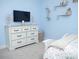 Bedroom featuring a white dresser with a TV and decorative shelving at 6470 Ashley Dr, Lakeland, FL 33813