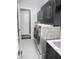 Functional laundry room featuring modern washer and dryer units, storage cabinets, and a convenient sink at 6470 Ashley Dr, Lakeland, FL 33813