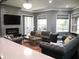 Spacious living room featuring leather sofas, a stone fireplace, and large windows for ample natural light at 6470 Ashley Dr, Lakeland, FL 33813
