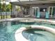 The screened-in pool area has a raised hot tub, pavers, built-in bar, and covered seating, for outdoor entertainment at 6470 Ashley Dr, Lakeland, FL 33813