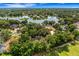 Scenic aerial view of the home with a lake view in a neighborhood surrounded by mature trees and lush landscaping at 6704 Crescent Lake Dr, Lakeland, FL 33813