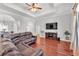 Spacious living room with tray ceiling, recessed lights, hardwood floors, and brown leather sofa at 6720 Highlands Creek Loop, Lakeland, FL 33813