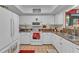 Well lit Kitchen featuring white cabinets, tile floors, and granite countertops at 6725 Trail Ridge Dr, Lakeland, FL 33813