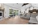 Open-concept living room with ample seating, a stone fireplace, and sliding doors to the back patio at 6745 Old Melbourne Hwy, St Cloud, FL 34771