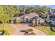 Stunning aerial view of home with circular driveway, mature trees, and manicured lawn at 6774 Crescent Woods Cir, Lakeland, FL 33813