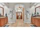 Elegant bathroom featuring dual sinks, granite countertops, wood cabinets, and an archway leading to a vanity area at 6774 Crescent Woods Cir, Lakeland, FL 33813