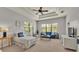 Sitting area in a neutrally decorated bedroom with large windows and simple furniture at 6774 Crescent Woods Cir, Lakeland, FL 33813