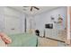 Well-lit bedroom with desk, dresser, and a bed with a patterned pillow and a soft green comforter at 6774 Crescent Woods Cir, Lakeland, FL 33813