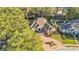 An aerial view of the house with mature trees, pavered driveway, and beautifully landscaped yard at 6774 Crescent Woods Cir, Lakeland, FL 33813