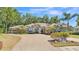 Beautiful home with a well-manicured lawn, pavered driveway, and stone accents at 6774 Crescent Woods Cir, Lakeland, FL 33813